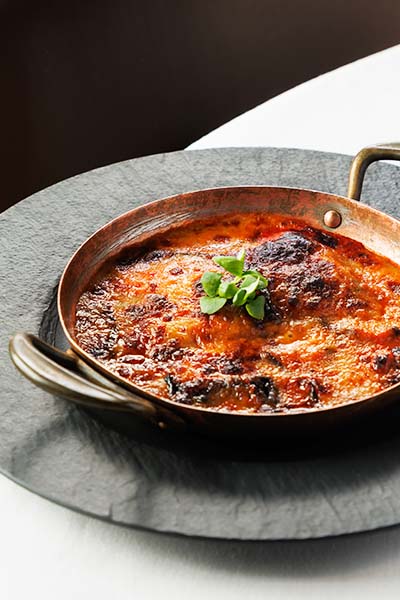 Lasagne on a white cloth dining table.