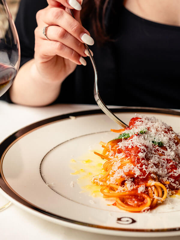 Giannino's Delicious spaghetti with a tangy tomato sauce, ready to be enjoyed with a fork.